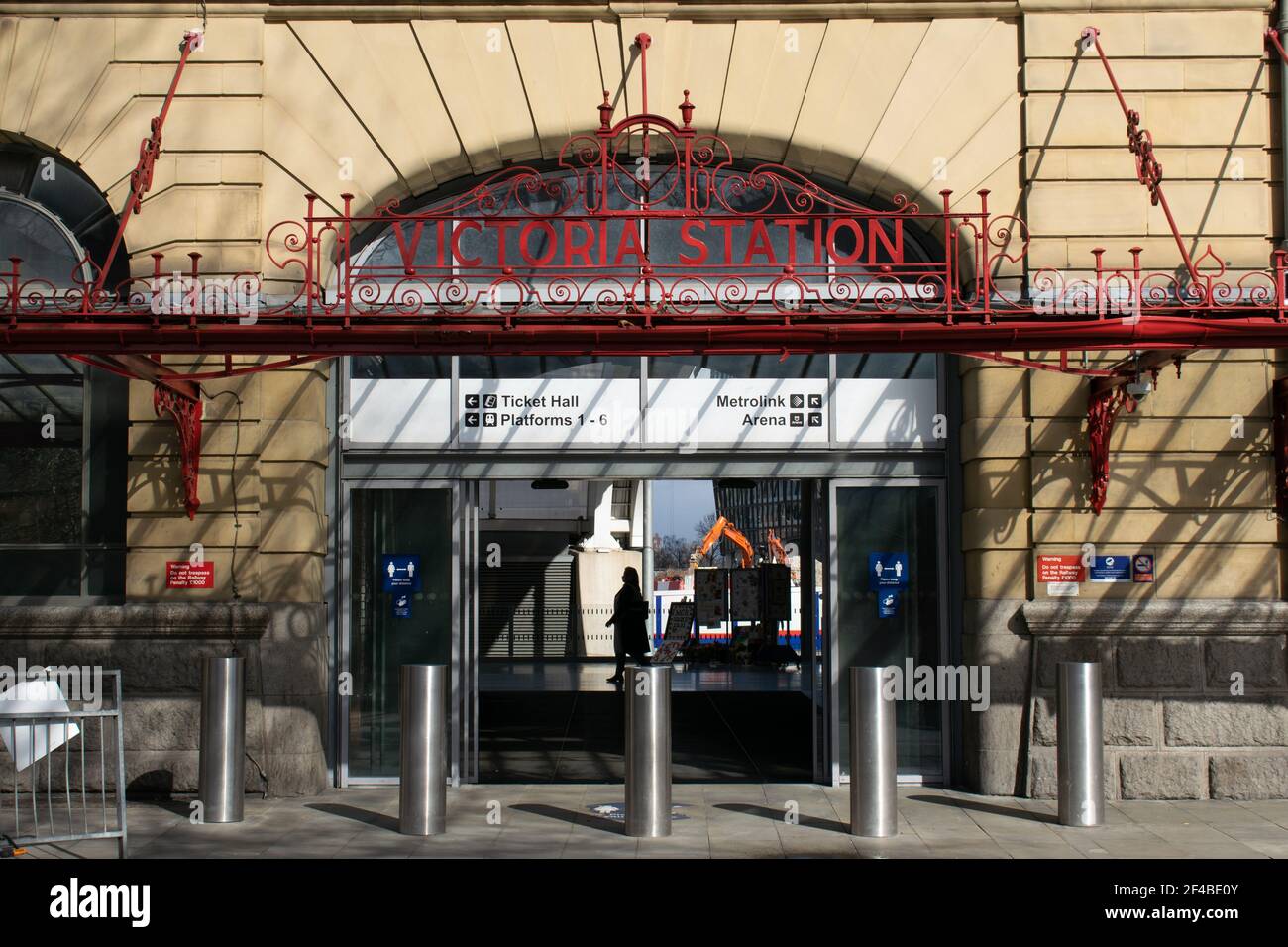 Manchester Victoria Railway Station Eingang mit Crash Poller und Passagier auf Plattform in Silhouette. Greater Manchester, Großbritannien Stockfoto