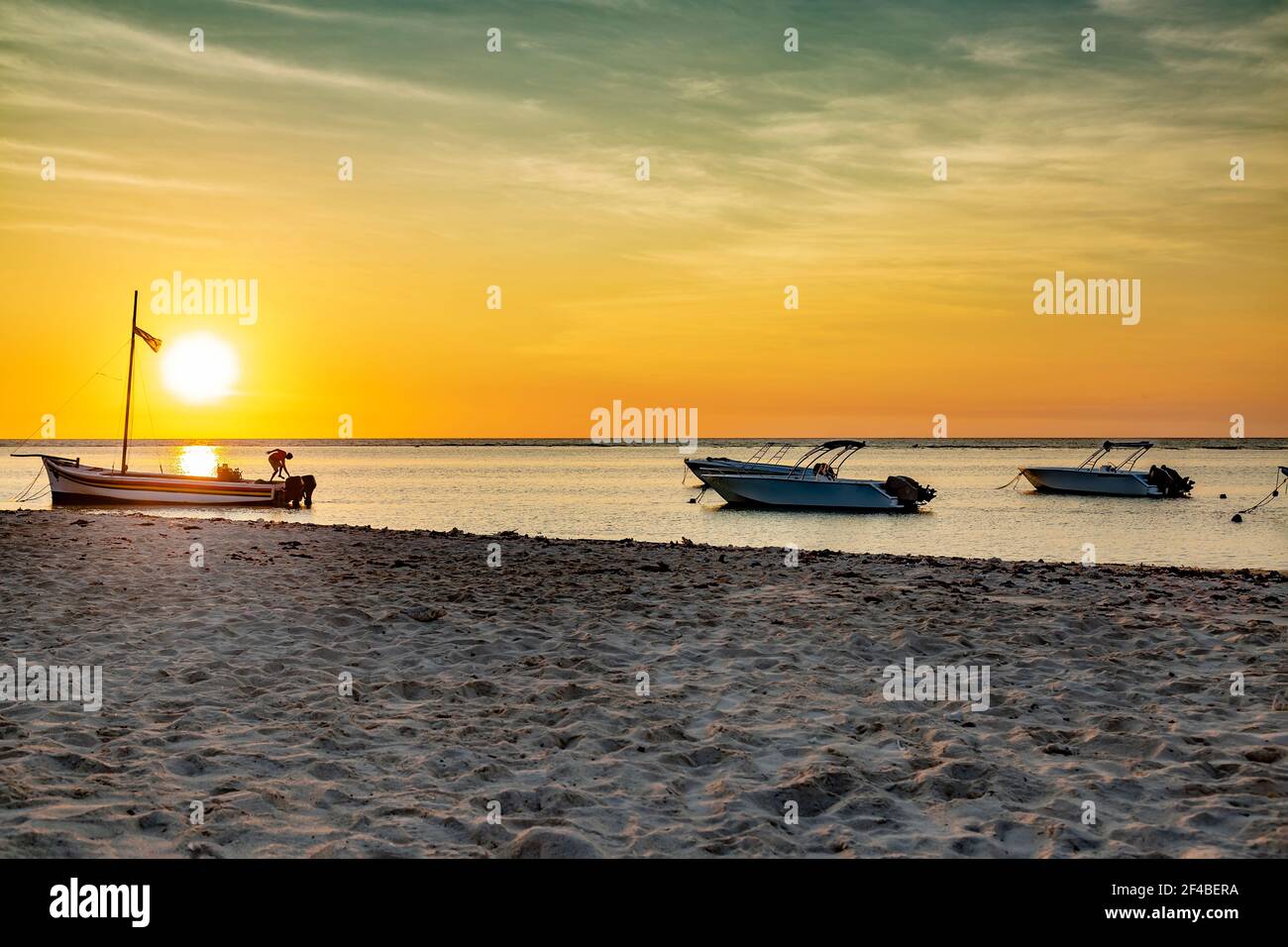 Fischerboot bei Sonnenuntergang am öffentlichen Strand von Flic En Flac Stockfoto
