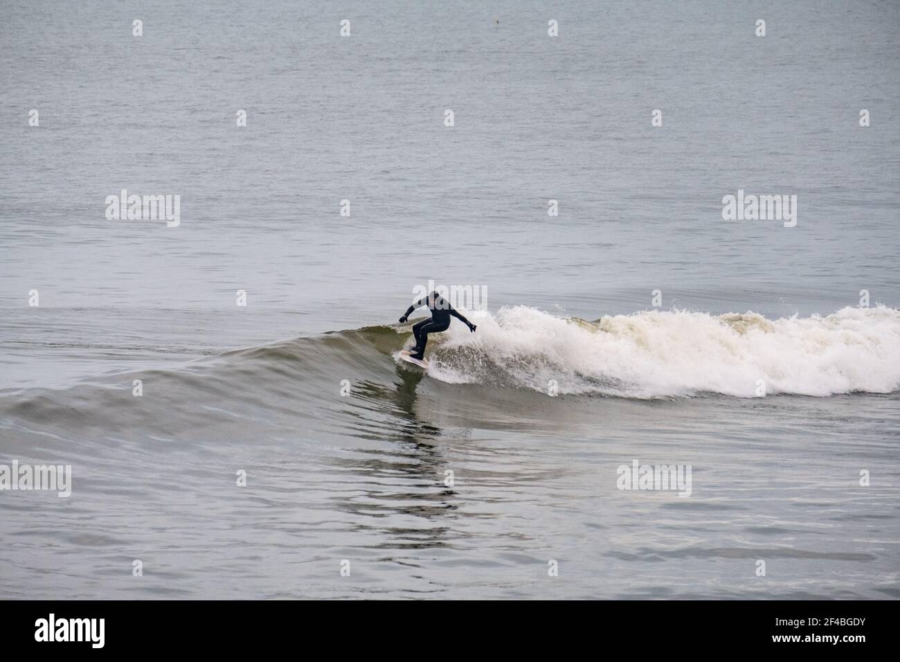 Surfer genießen die Wellen in Aberystwyth, Wales. Stockfoto