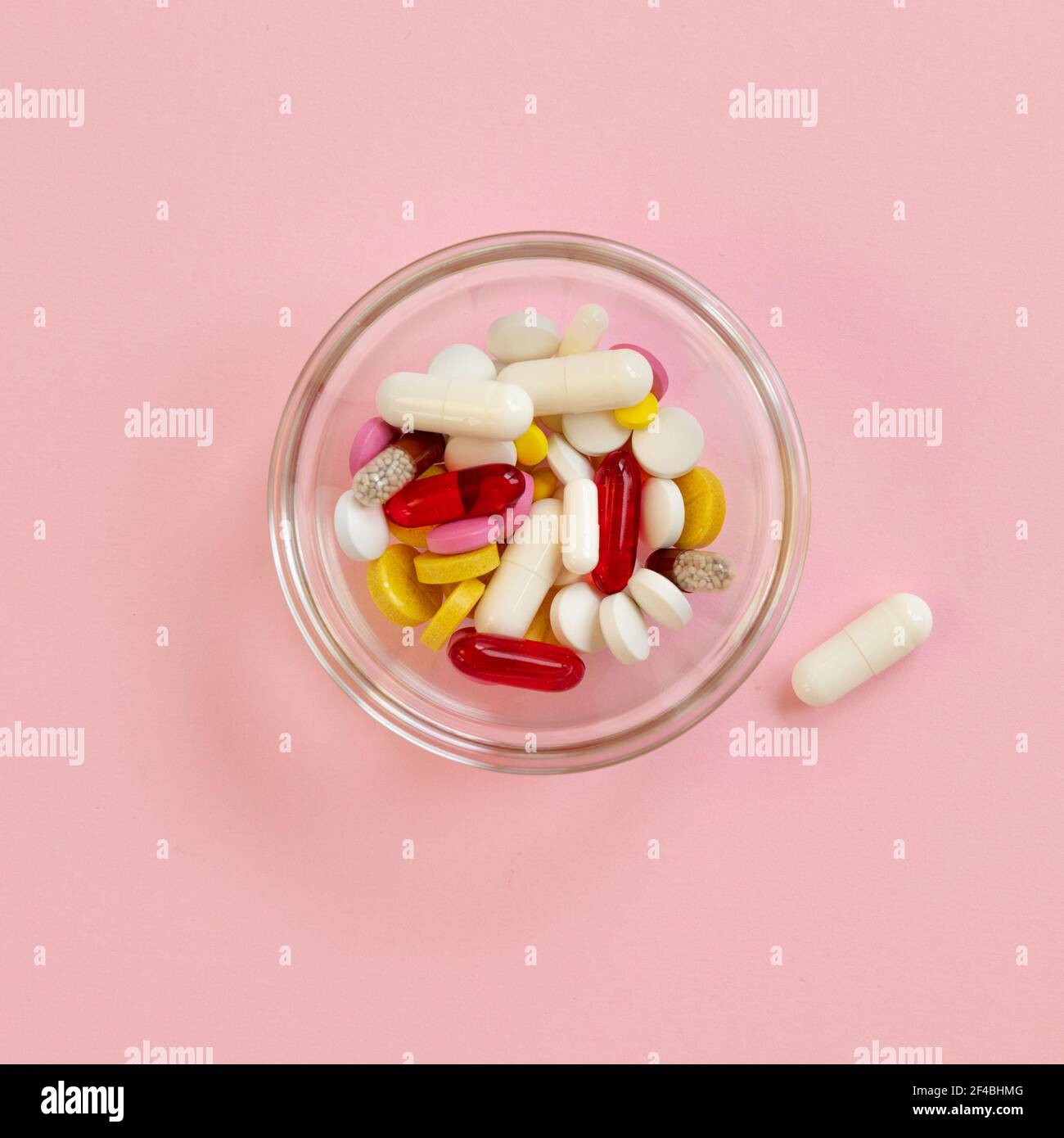 Mehrfarbige Pillen und Kapseln, Tabletten gegen das Virus, Grippe, Krankheit auf rosa Hintergrund. Medizinisches Konzept des Virus-Pandemieschutzes, Coronaviru Stockfoto