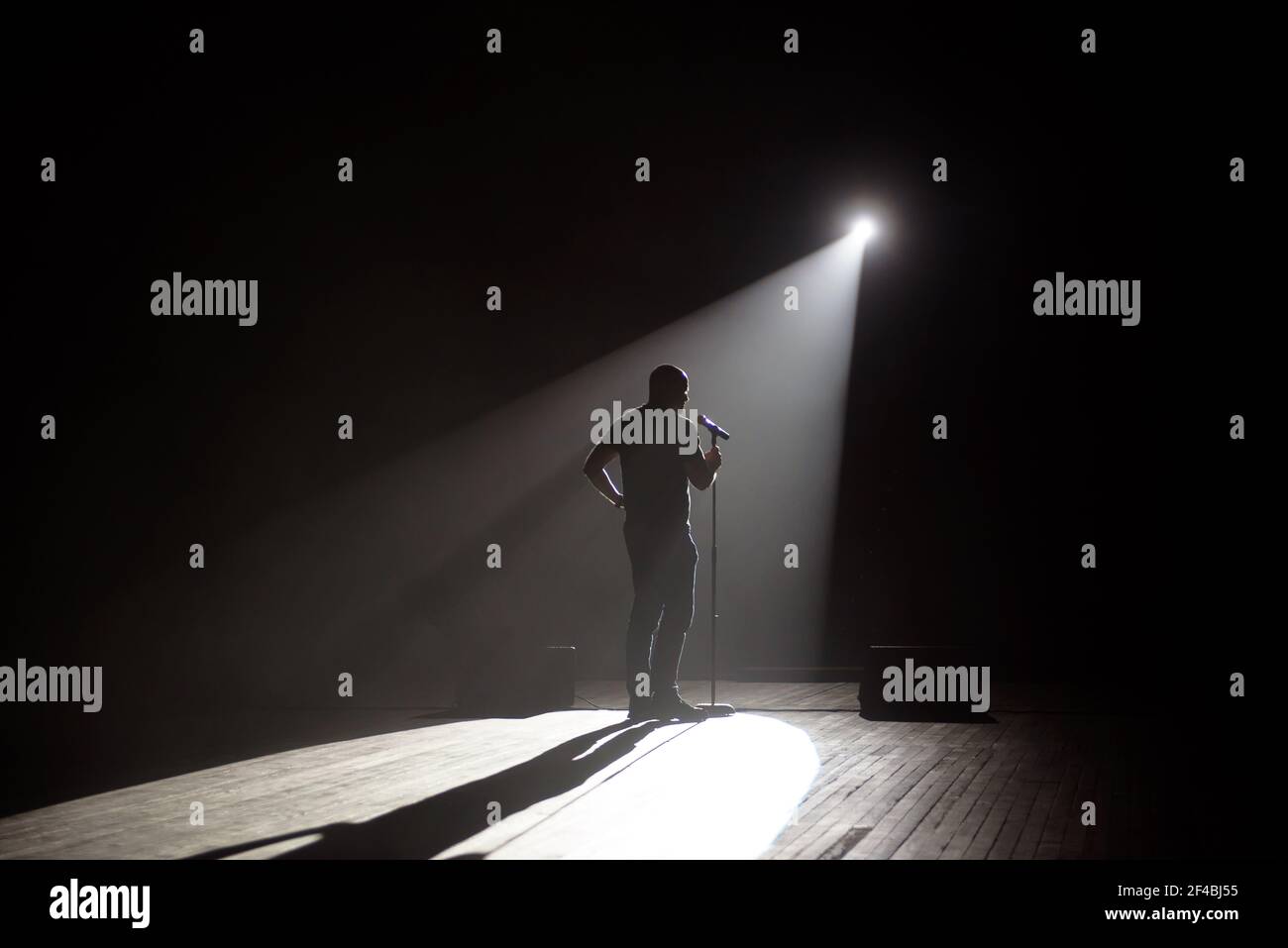 Stand up Comedian auf der Bühne im Lichtstrahl. Stockfoto
