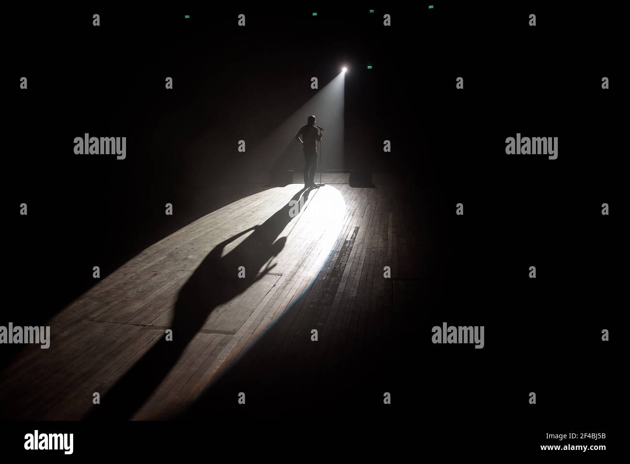 Stand up Comedian auf der Bühne im Lichtstrahl. Stockfoto