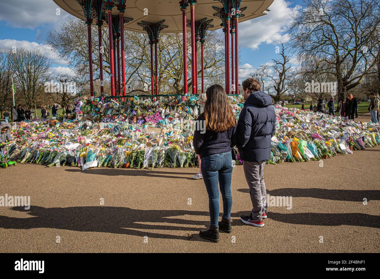 LONDON, ENGLAND - MÄRZ 19: Ein Paar schaut sich die floralen Tribute an, die am 19 2021. März in London, Großbritannien, am Bandstand auf Clapham Common hinterlassen wurden. © Hor Stockfoto