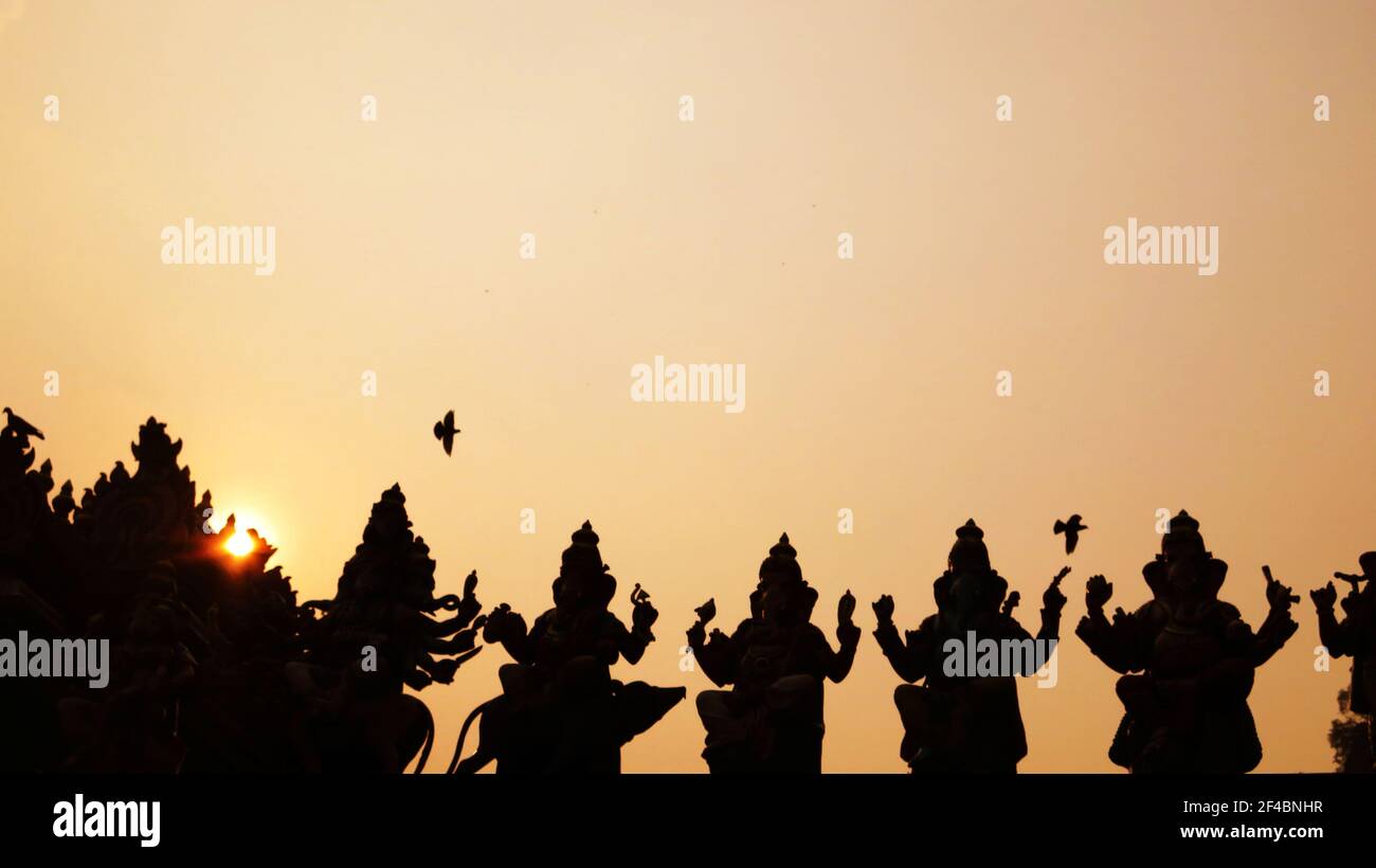 Hinduistische Statuen in Silhouette bei Sonnenuntergang : Religiöse Statuen in Batu Caves, eine Stätte von Hindu-Höhlentempel und Schrein Stockfoto