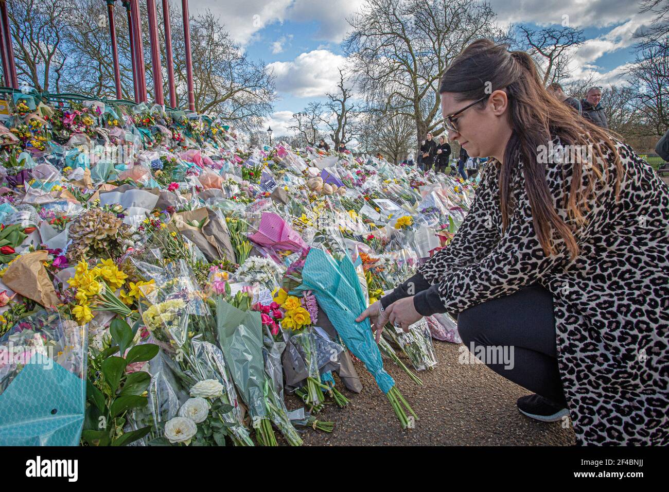 LONDON, ENGLAND - 19. MÄRZ: Frau legt Blumen zu Ehren der ermordeten Sarah Everard am Bandstand auf Clapham Common am 19. März 2021 in London, Stockfoto