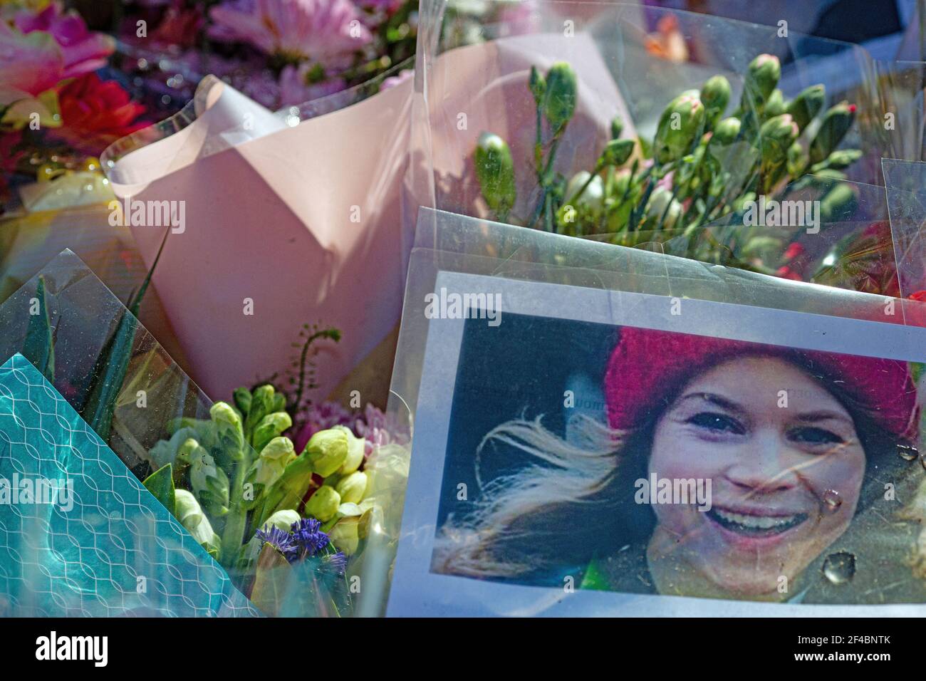 LONDON, ENGLAND - MÄRZ 19: Ein Bild von Sarah Everard sitzt zwischen Blumen links am Bandstand, Clapham Common, wo Blumen Tribute wurden bui Stockfoto
