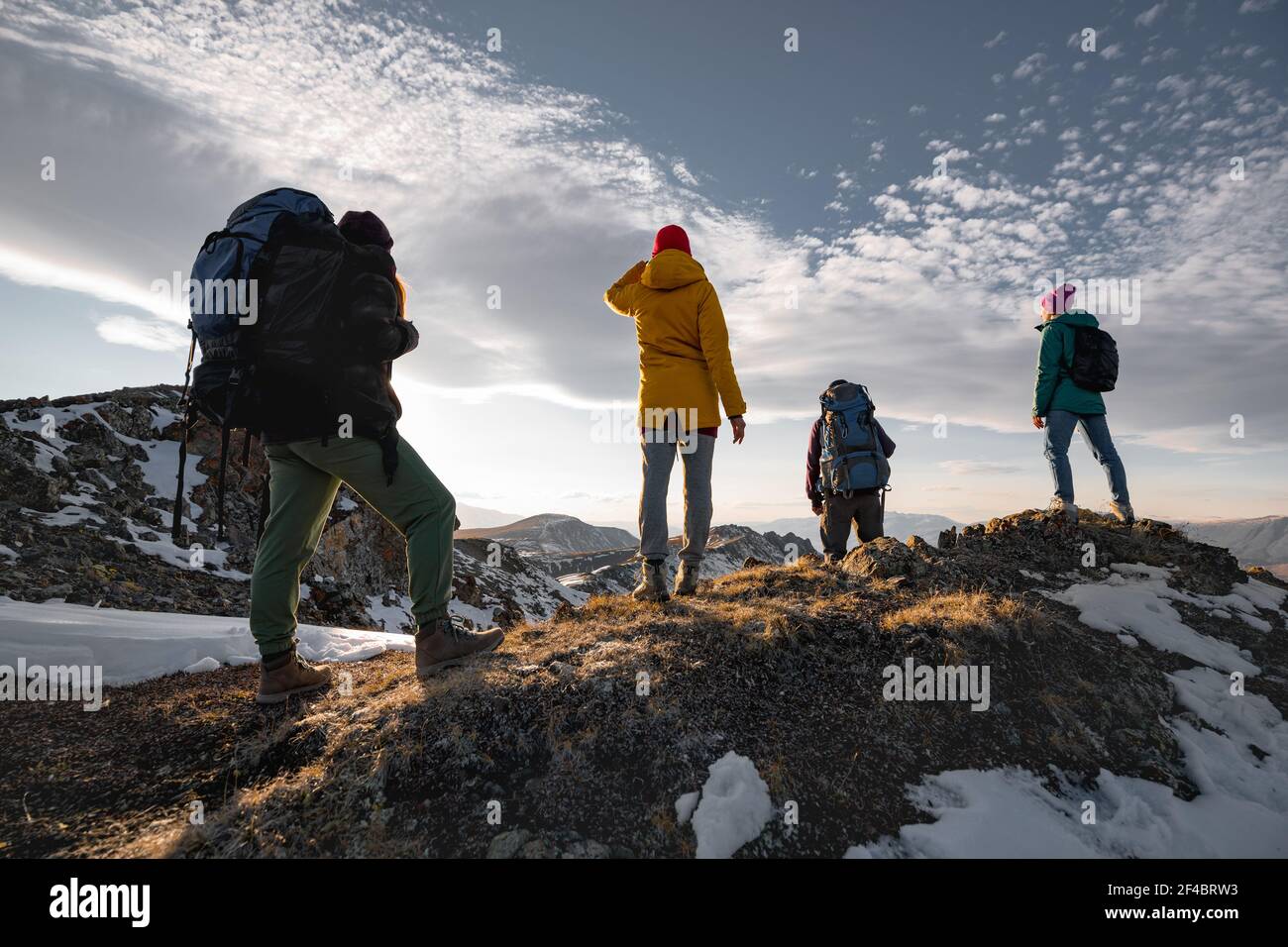 Vier unkenntliche Wanderer entspannen sich auf dem Berggipfel Stockfoto