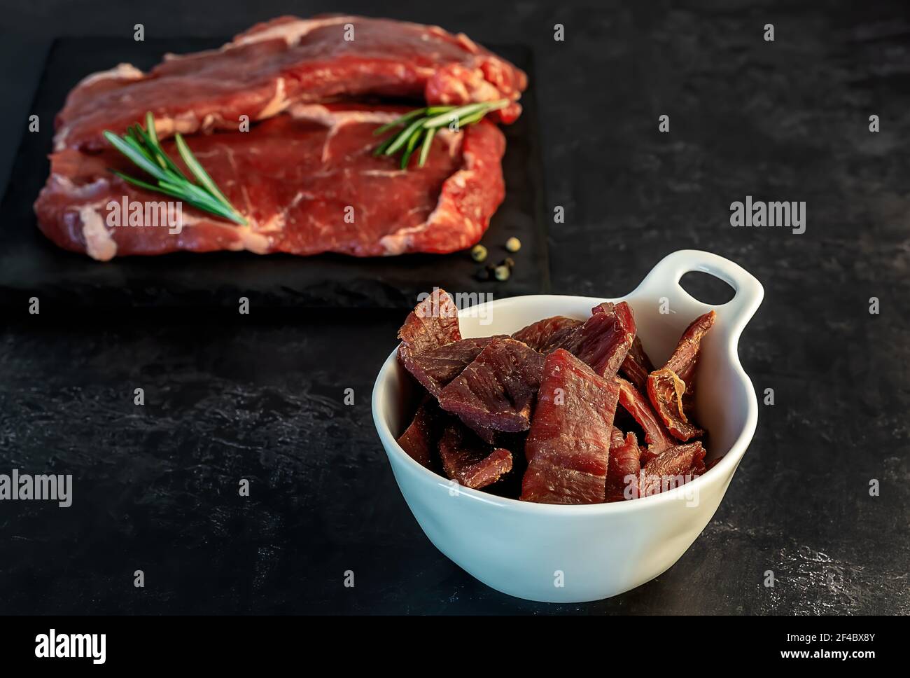 Jerky Snack reich an Eiweiß aus magerem Rindfleisch. Geräucherte, getrocknete Lebensmittel mit Fleisch geschnitten und Pfeffer. Stockfoto