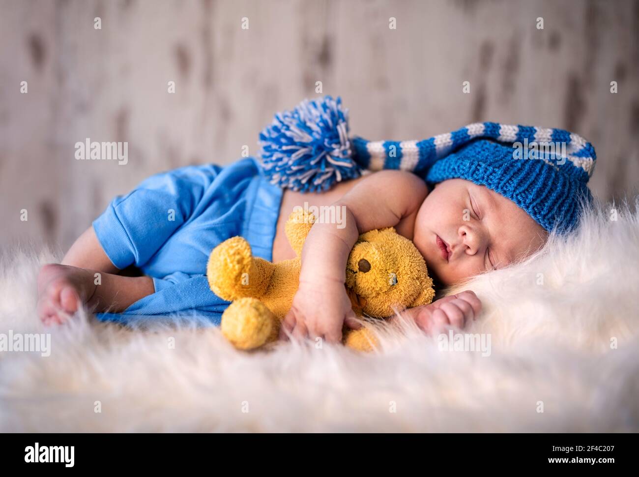 Neugeborener Junge friedlich schlafen mit seinem weichen Teddybär Stockfoto