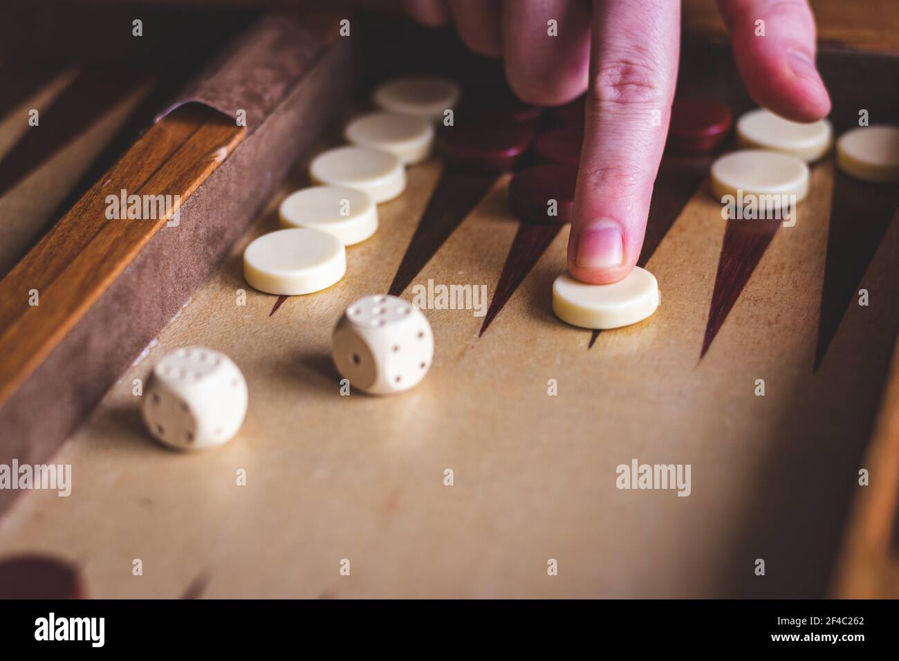 Backgammon-Spiel spielen. Mann´s Hand bewegen Gammon an Bord Spiel. Würfel auf Holzbrett Stockfoto