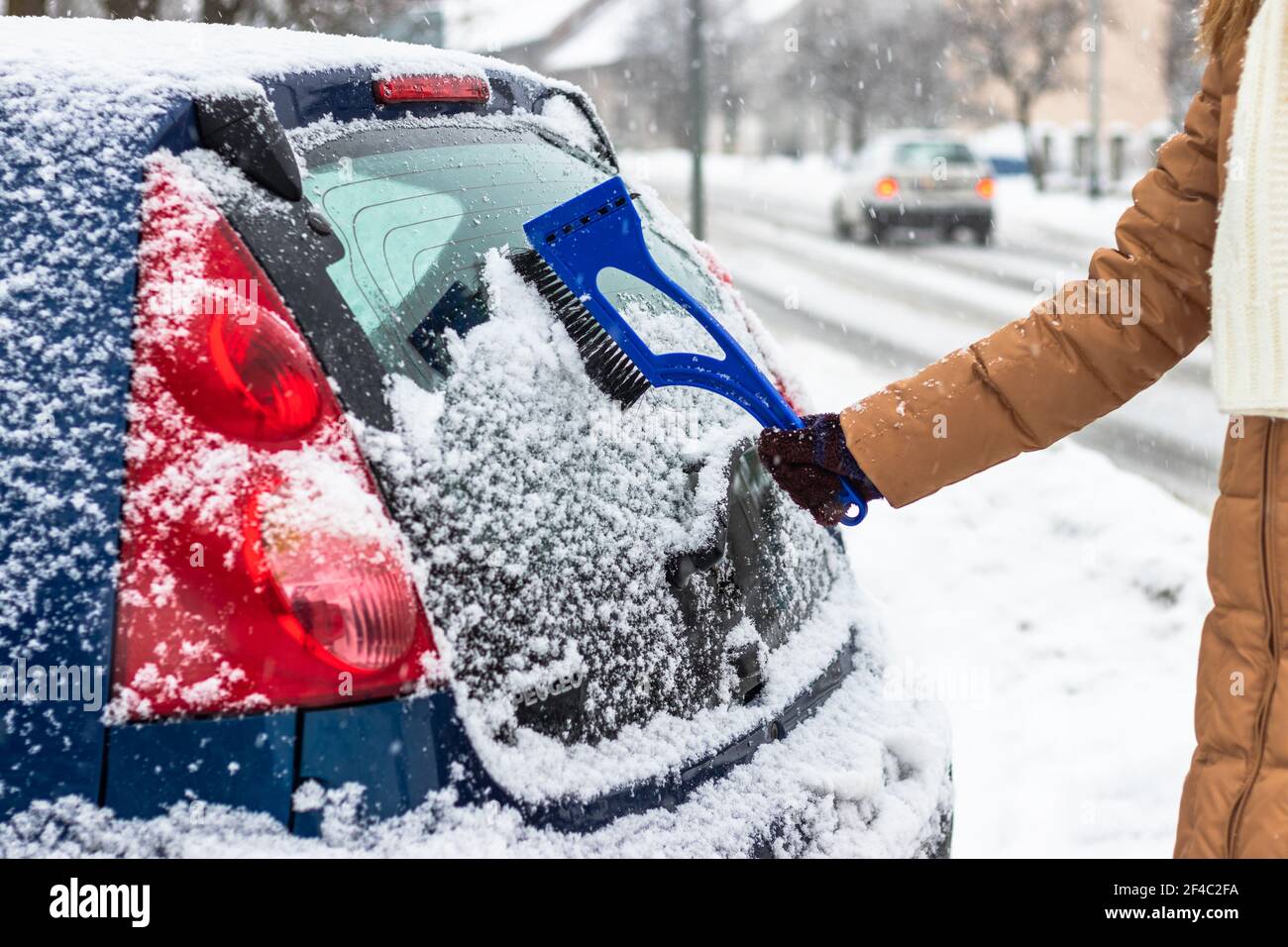 Entfernen von Schnee aus dem Autofenster auf der Straße. Reinigung des  Autos während des Schnees im Winter Stockfotografie - Alamy