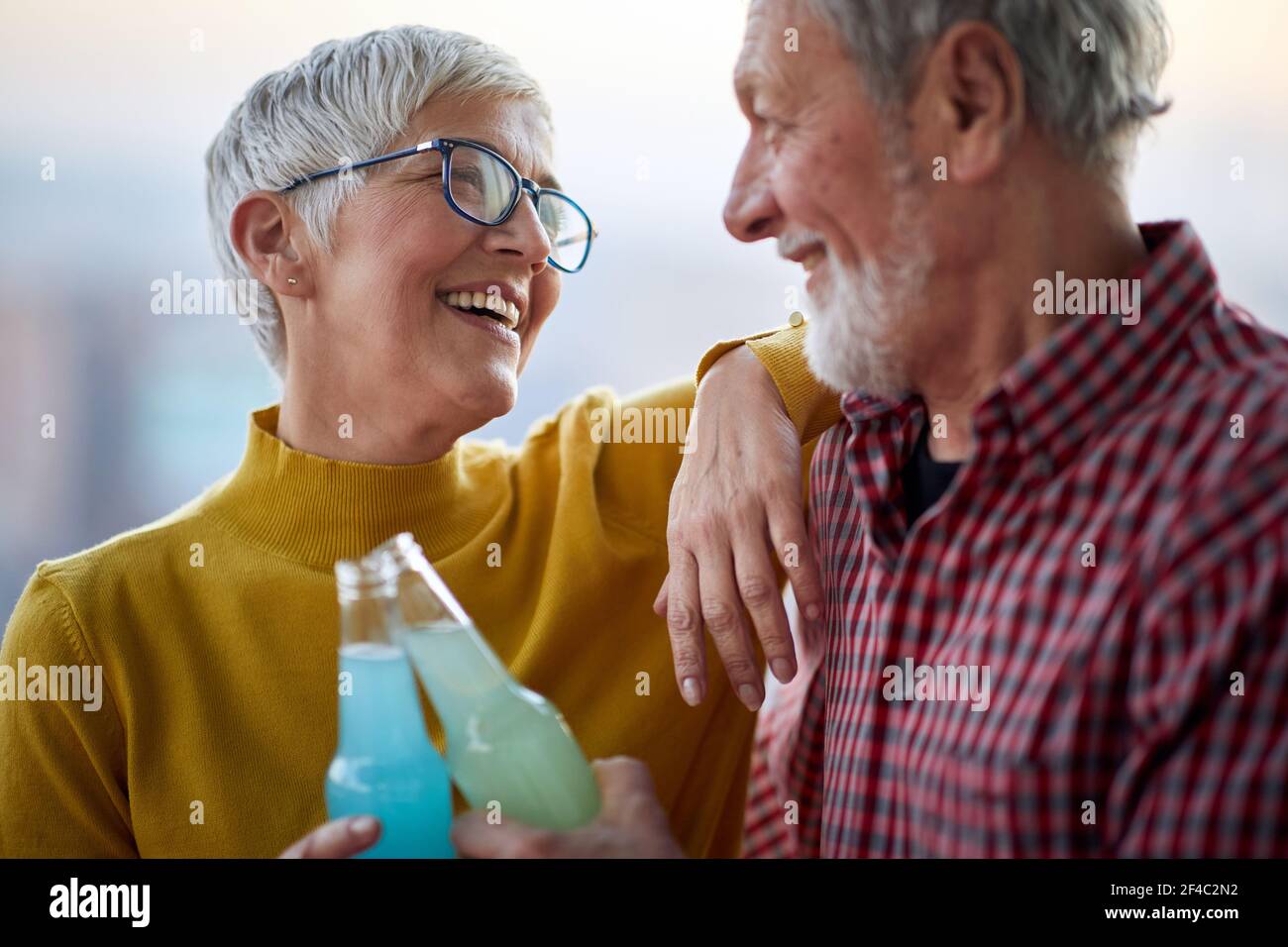 Ein glückliches älteres Paar genießt einen Drink und verbringt Zeit zusammen in einer fröhlichen Atmosphäre. Ehepartner, ältere Menschen, zusammen Stockfoto
