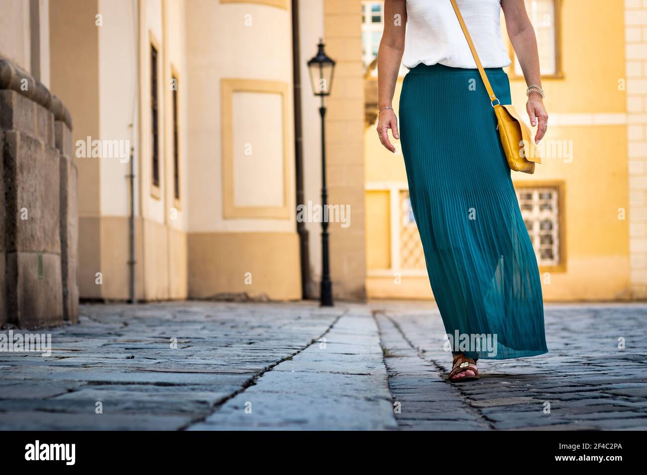 Frau in grünen Faltenrock gekleidet ist zu Fuß in der Altstadt. Stilvolles und modisches Konzept Stockfoto