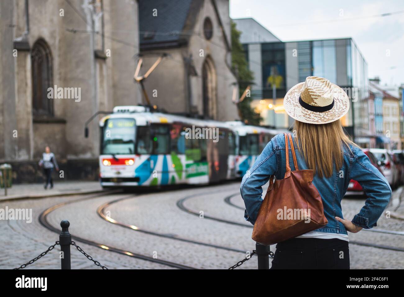 Frau Tourist ist an vorbeifahrenden Straßenbahn in der antiken Stadt Olomouc, Tschechische Republik, Europa suchen. Transport in der europäischen Stadt Stockfoto