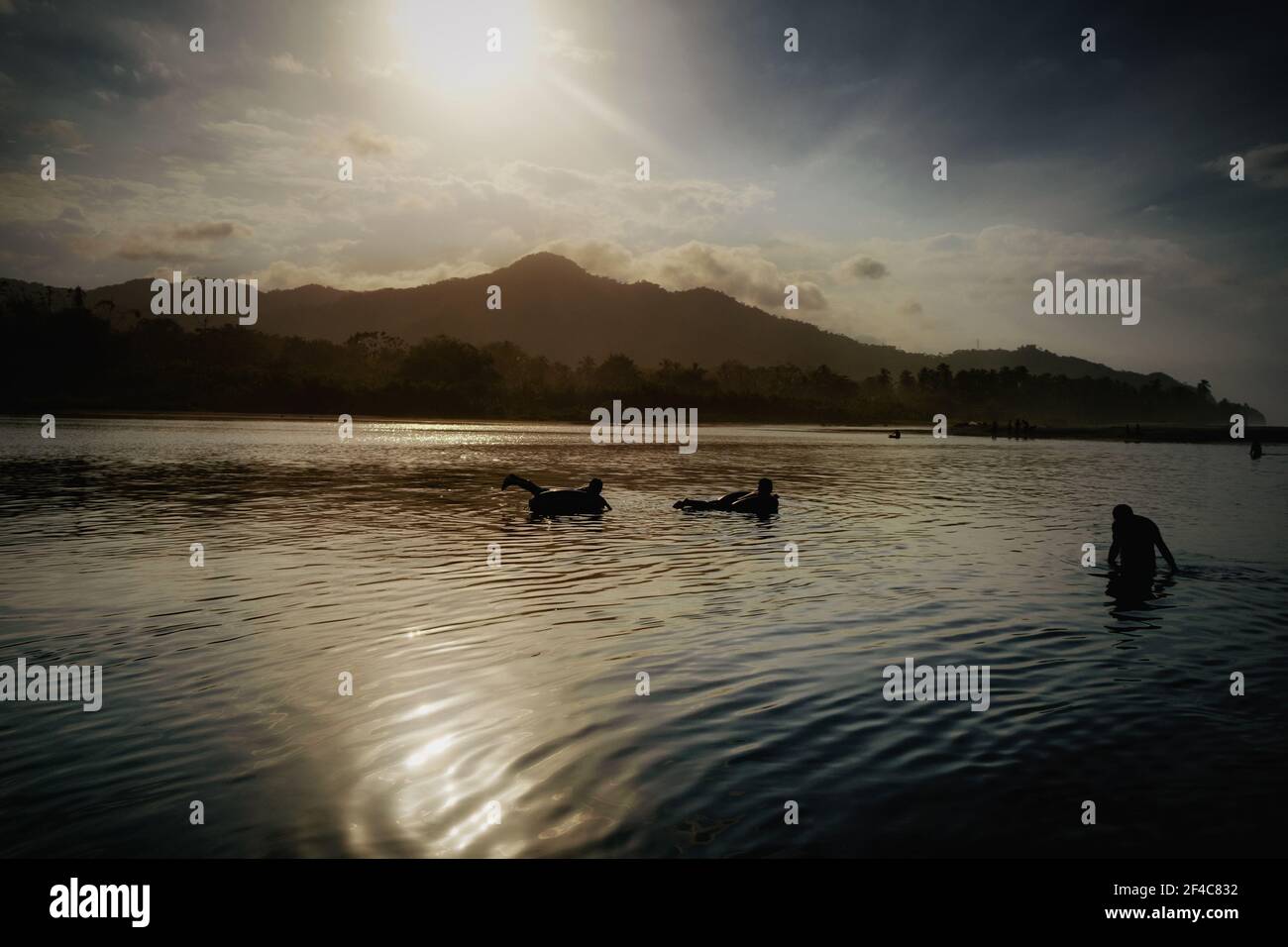 Jugendliche schweben bei Sonnenuntergang in Palomino, Kolumbien, auf Innenrohren den Palomino River hinunter. Stockfoto