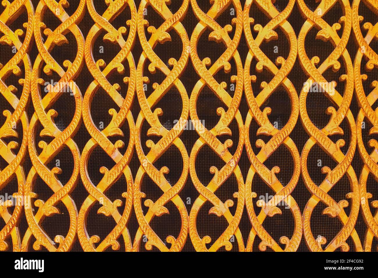 Nahaufnahme eines kunstvoll geschmiedeten, goldbedeckten Luftkanalnetzes im arabischen Stil. Orientalisches Blumenmuster des Lüftungsgitters. Stockfoto