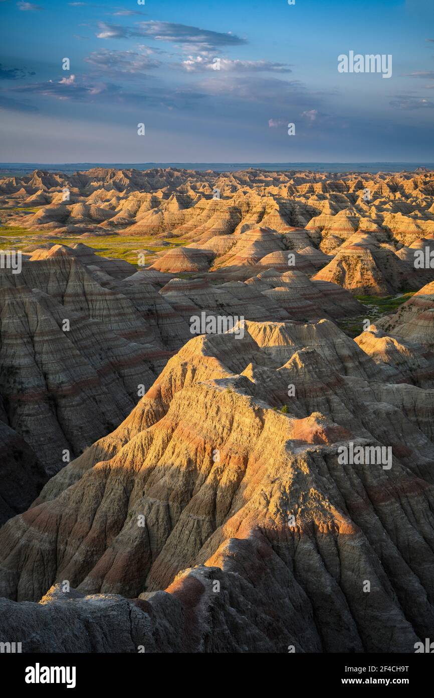 Sonnenaufgangslicht regt die erodierten Zinnen und Schluchten bei Big Badlands Overlook im Badlands National Park, South Dakota. Stockfoto