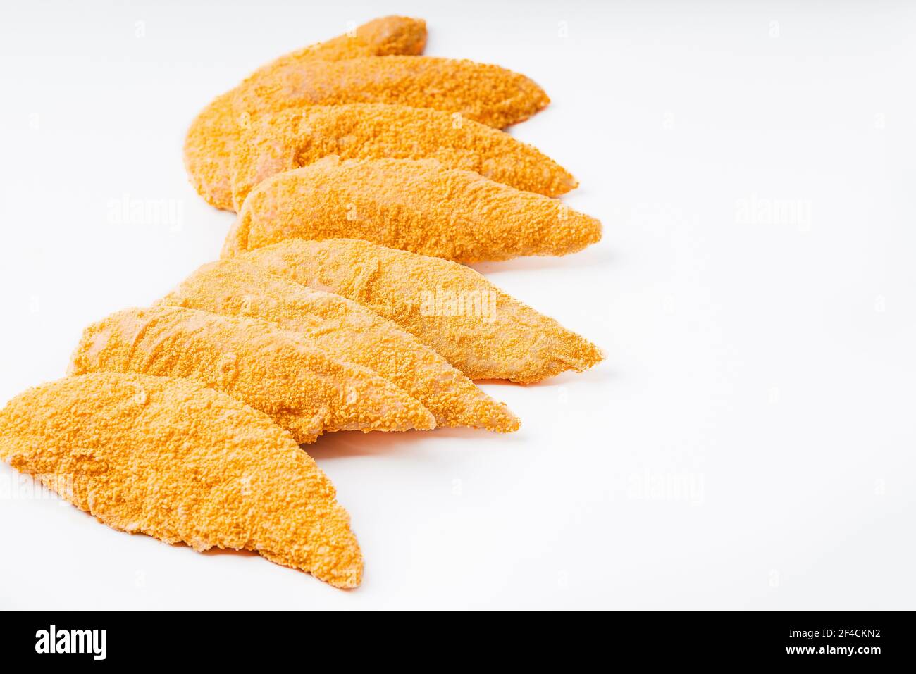 Schnelles Kochen.Paniertes Huhn Innenfilet auf einem weißen Hintergrund.Huhn paniertes rohes Fleisch. Stockfoto