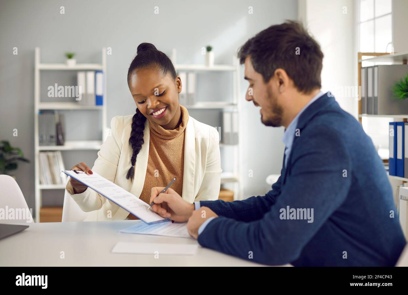 Geschäftsfrau hält Zwischenablage und Mann Unterzeichnung Papier Vertrag Stockfoto