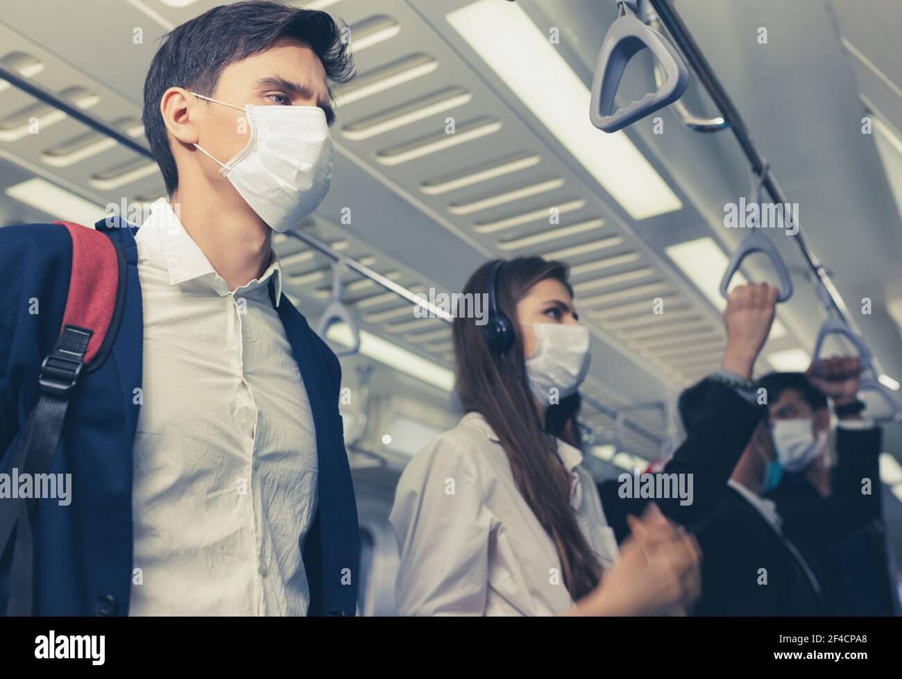 Die Menschen im Zug tragen Antivirenmasken und reisen während der Hauptverkehrszeiten. Passagiere im Sky Train mit den Masken auf allen Gesichtern. Stockfoto