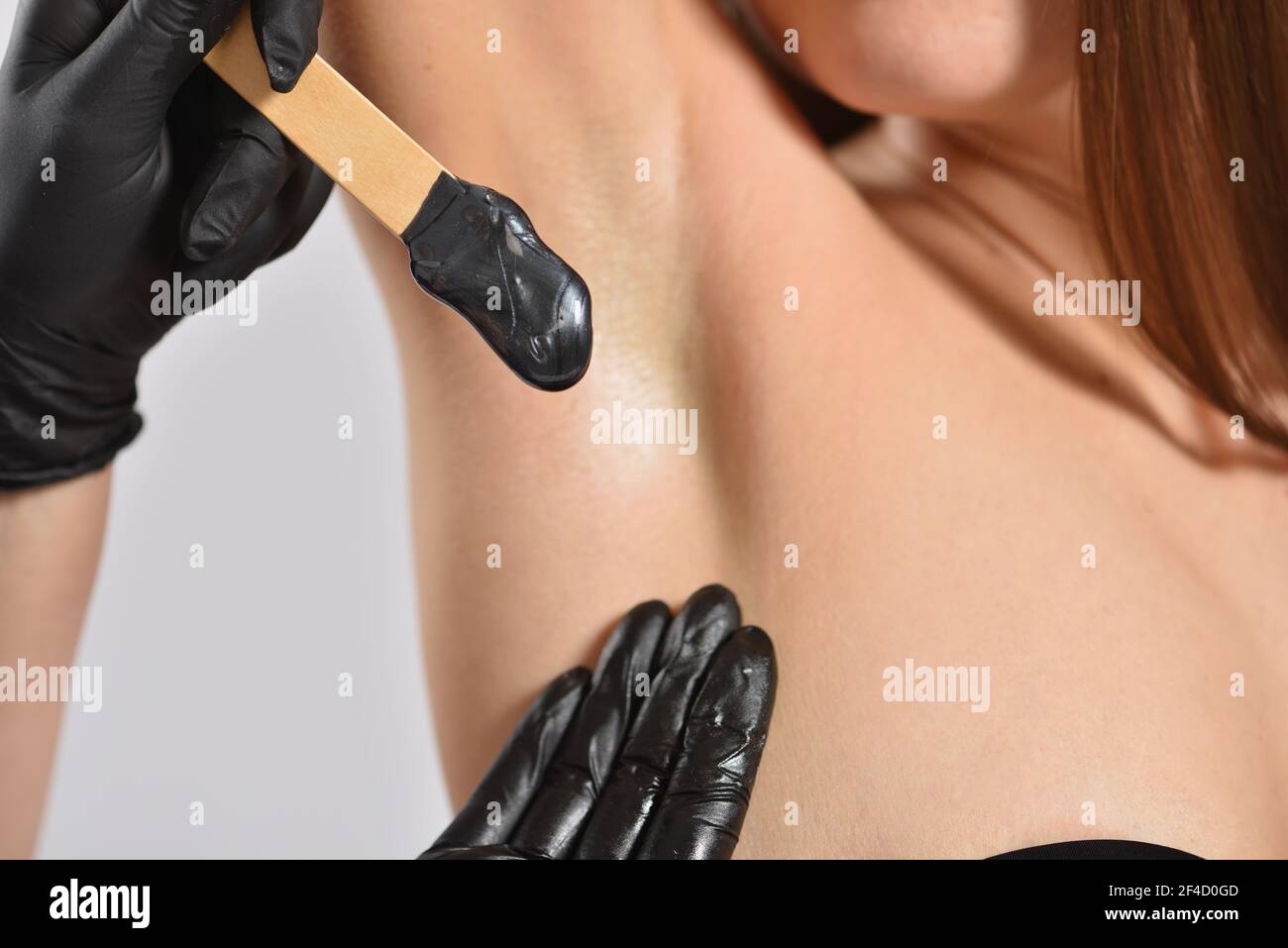 Stick mit schwarzem Wachs für Enthaarung auf Achselhöhlen Hintergrund, Körperpflege und Beauty-Konzept Stockfoto