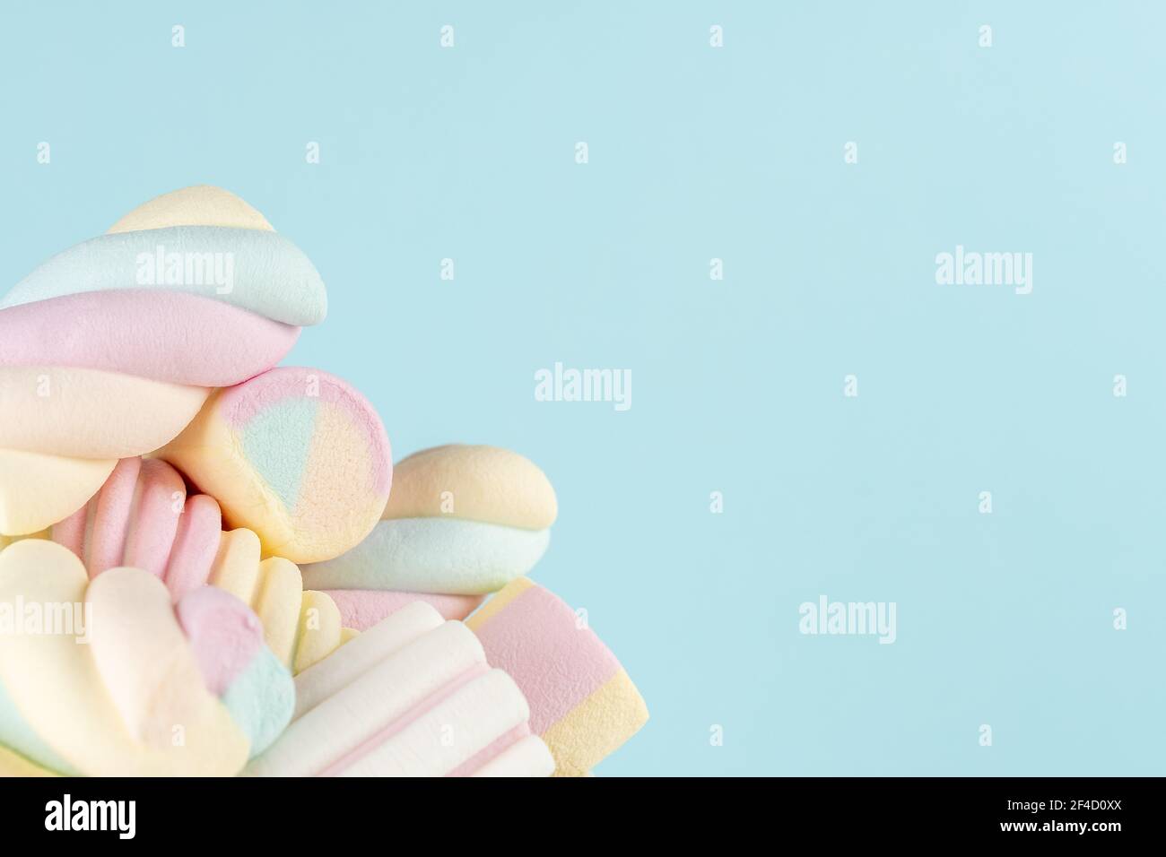 Marshmallows bunte Kaubonbons auf blauem Hintergrund. Sweet Holiday Food Konzept. Stockfoto