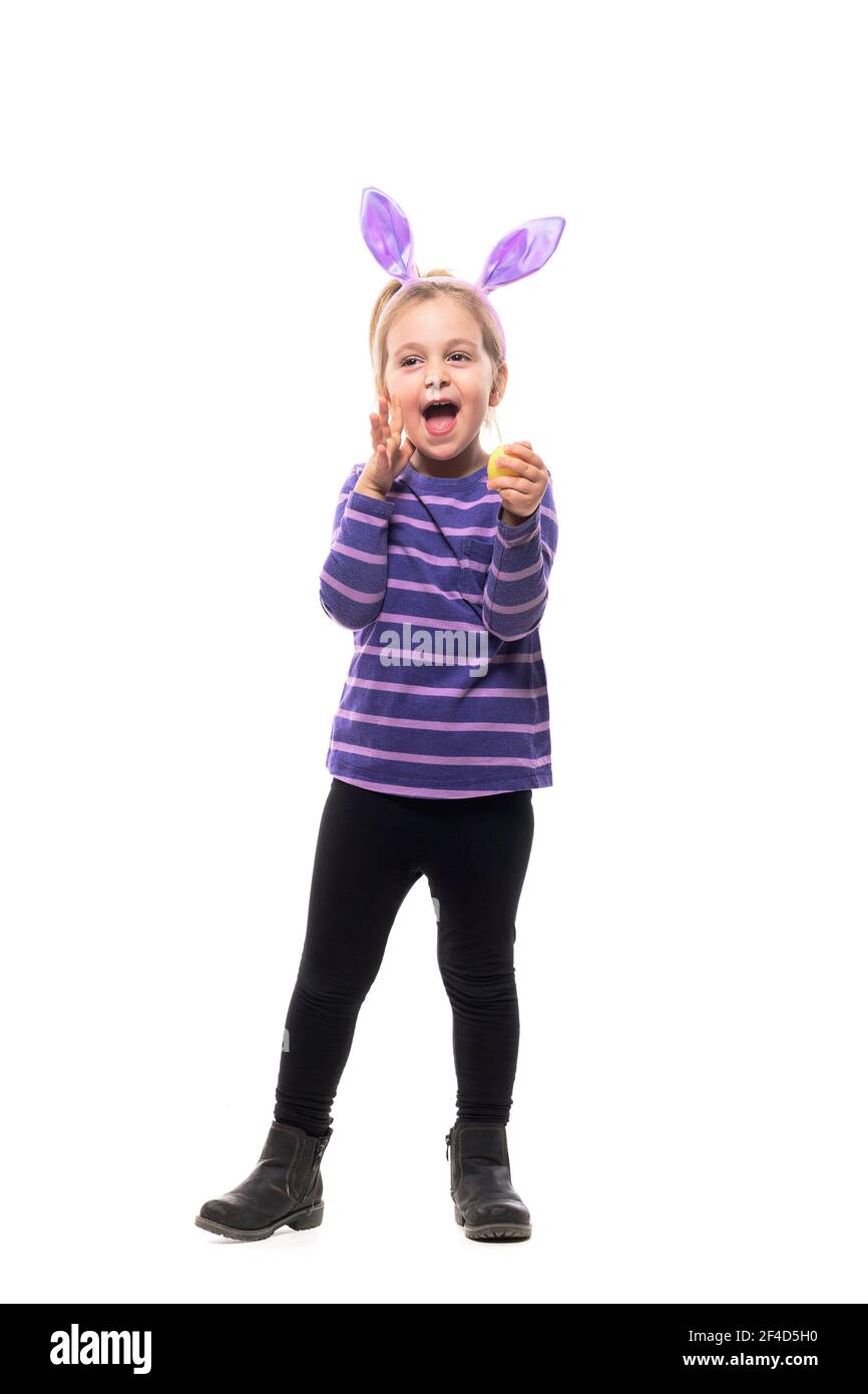 Fröhlich aufgeregt junge Mädchen mit Hasen Ohren schreien halten bemalte Osterei. Ganzkörper isoliert auf weißem Hintergrund Stockfoto