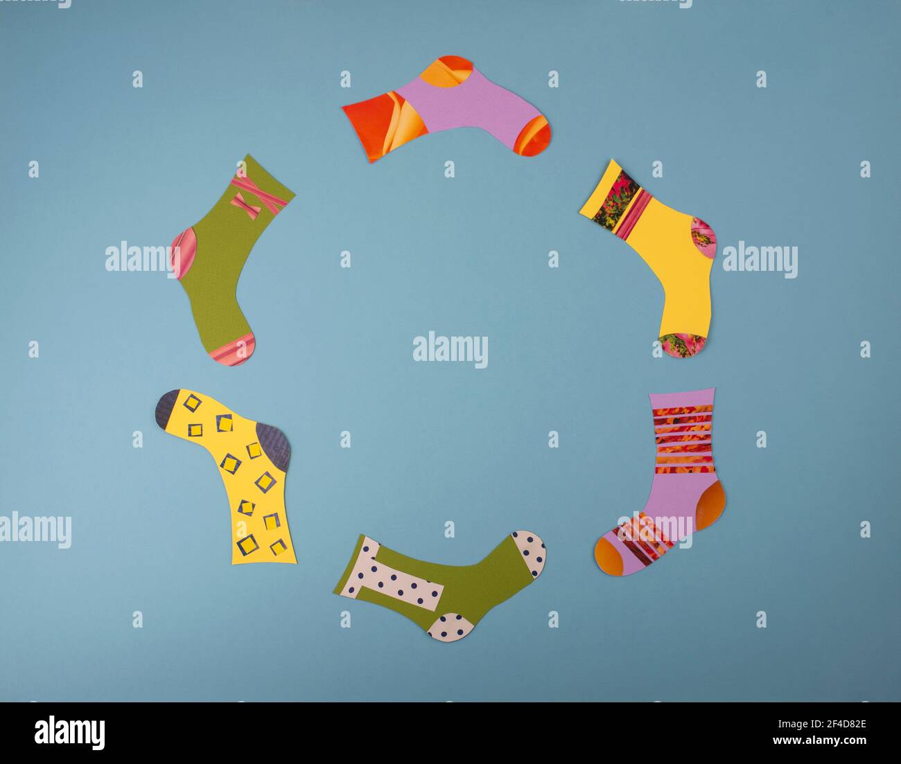 World Down Syndrome Day Konzept. Verschiedene Socken aus Papier auf blauem Hintergrund. Flach liegend, Draufsicht. Speicherplatz kopieren. Stockfoto