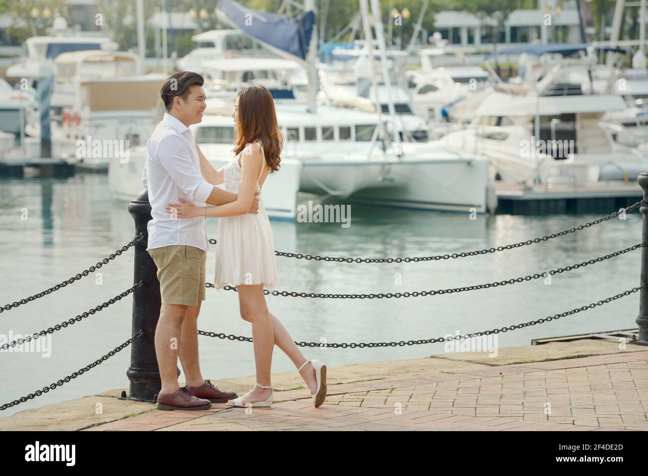 Porträt eines verliebten Paares, das an einer Marina in Singapur steht Stockfoto