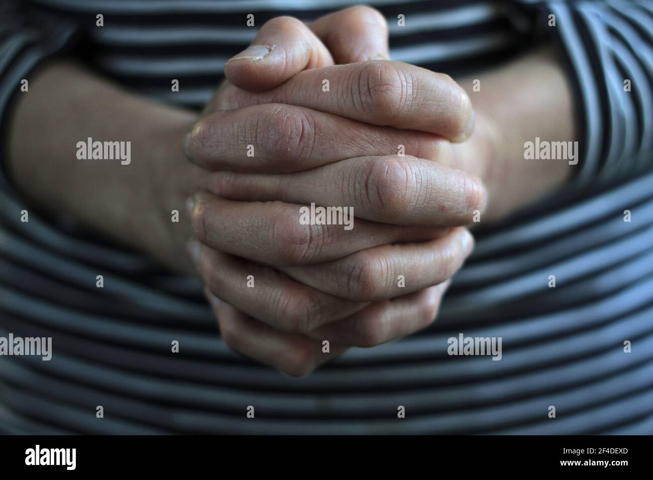 Frau betet Hände zusammen auf grauem Hintergrund Stock Foto Stockfoto