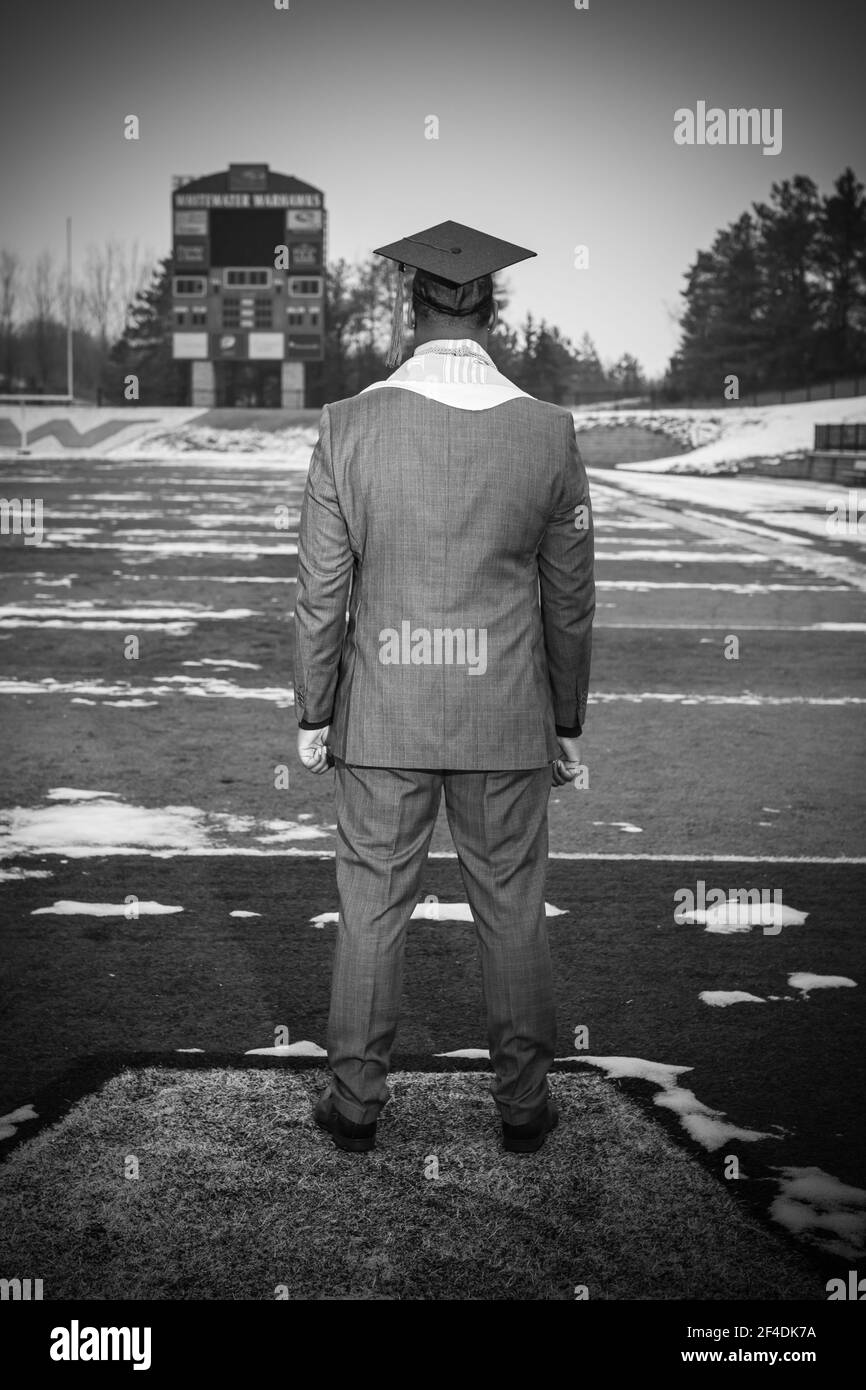 WILDWASSER, WI. USA DEC 19, 2020: NACH EINER VIRTUELLEN ABSCHLUSSFEIER SCHAUT EIN JUNGER AFROAMERIKANISCHER MANN ÜBER DIE FOOTBALL FEILD, WO ER SPIELTE. Stockfoto