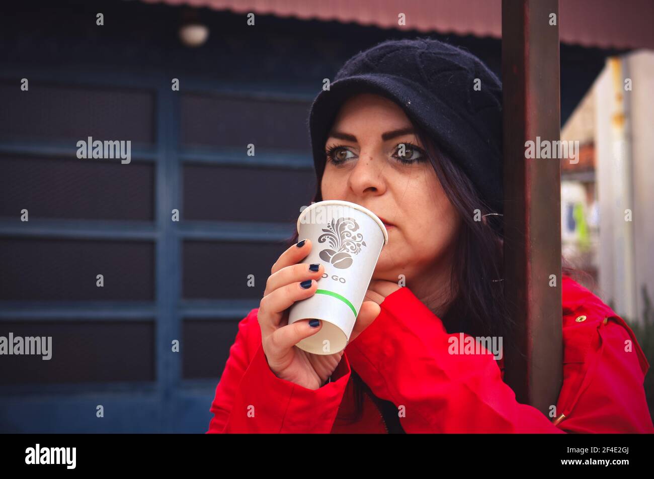 Eine Frau in Rot trinkt Kaffee Stockfoto