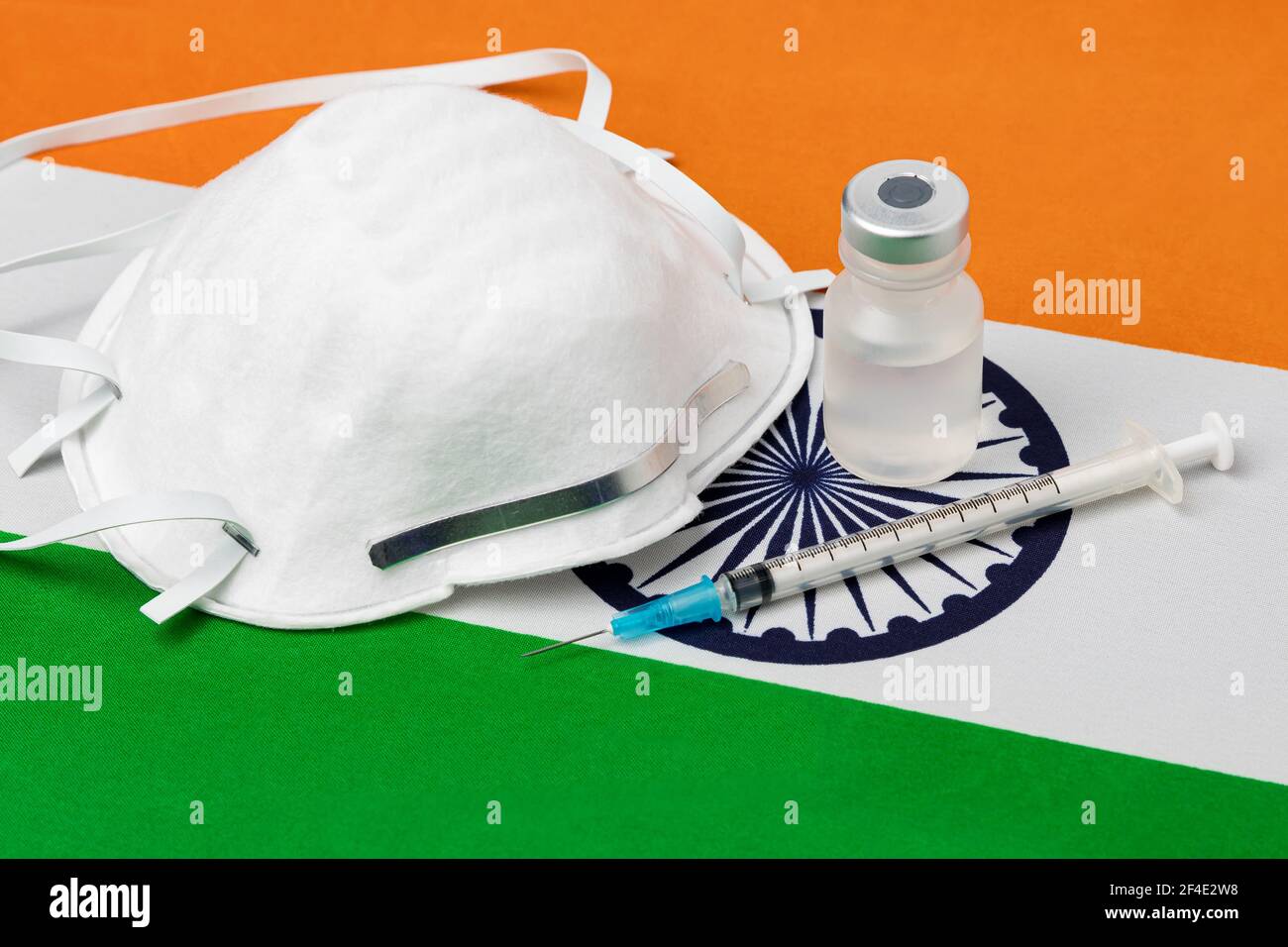 Indien Flagge, N95 Gesichtsmaske, Nadelspritze und Fläschchen. Konzept der Covid-19 Coronavirus-Impfstoffverteilung, Versorgungsengpässe und Gesundheitskrise Stockfoto