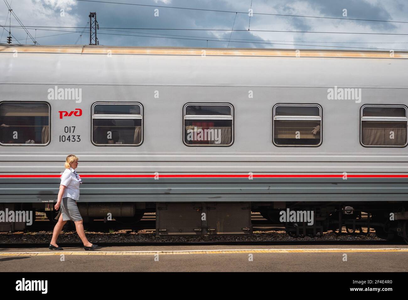 Ein Waggonwart der Provodnitsa am Bahnhof Nowosibirsk-Glavny in Nowosibirsk, Russland, ein wichtiger Halt entlang der Transsibirischen Eisenbahn. Stockfoto