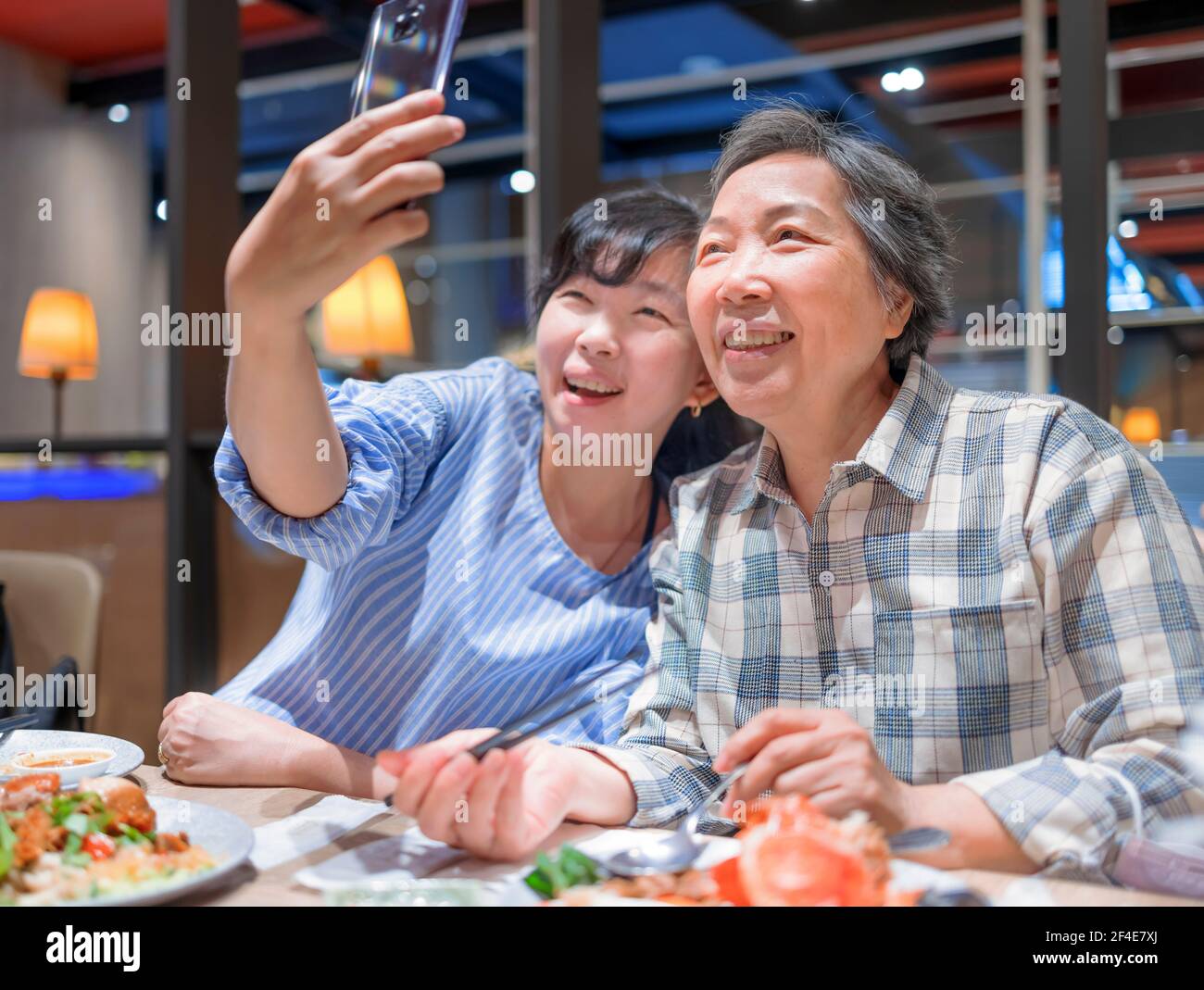 Glückliche Mutter und Tochter, die Selfie während einer Mahlzeit in Restaurant Stockfoto