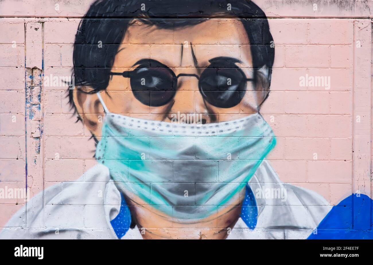 Graffiti auf einer öffentlichen Straße eines Mannes, der eine Brille und eine covid19 Maske trägt. Wandmalerei in Mexiko Stockfoto