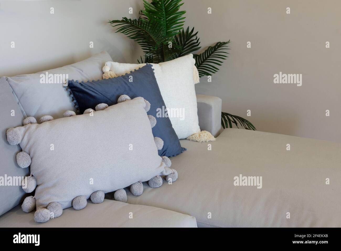 Eine gemütliche Ecke auf einem Sofa in einem Wohnzimmer mit vielen Kissen in neutralen Farbtönen. Stockfoto