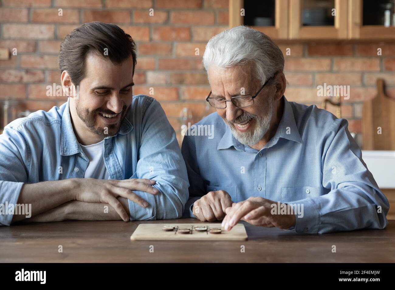 Glücklich reifen Vater und erwachsenen Sohn spielen Brettspiel Stockfoto