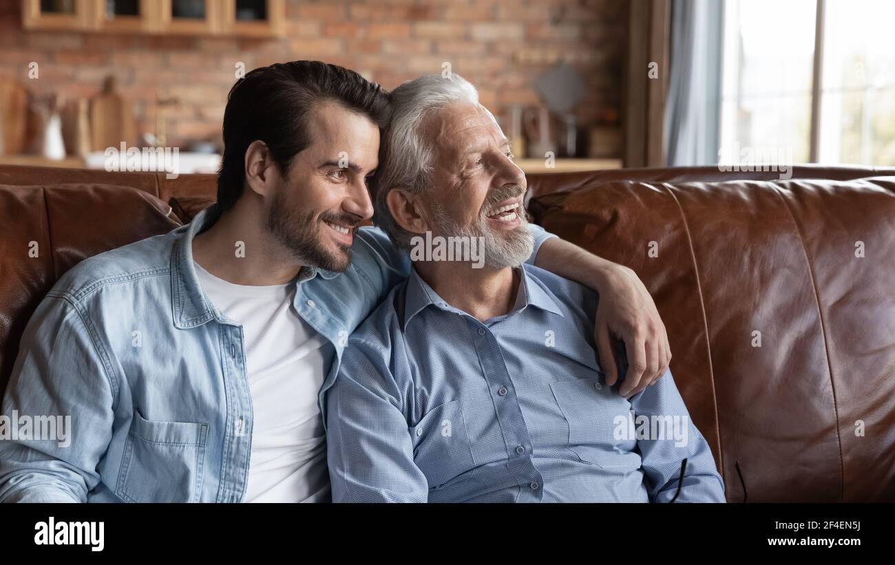 Glücklicher alter Vater und erwachsener Sohn träumen zu Hause Stockfoto