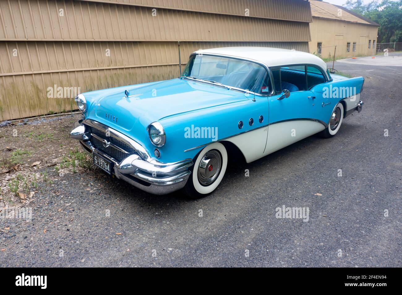 Hohe Seite auf Ansicht einer restaurierten klassischen blauen 1955 Buick Limousine vor industriellem Hintergrund mit Kopierraum. Stockfoto