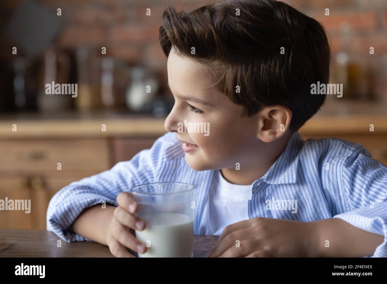 Kleiner kaukasischer Junge trinkt Milch aus Glas Stockfoto