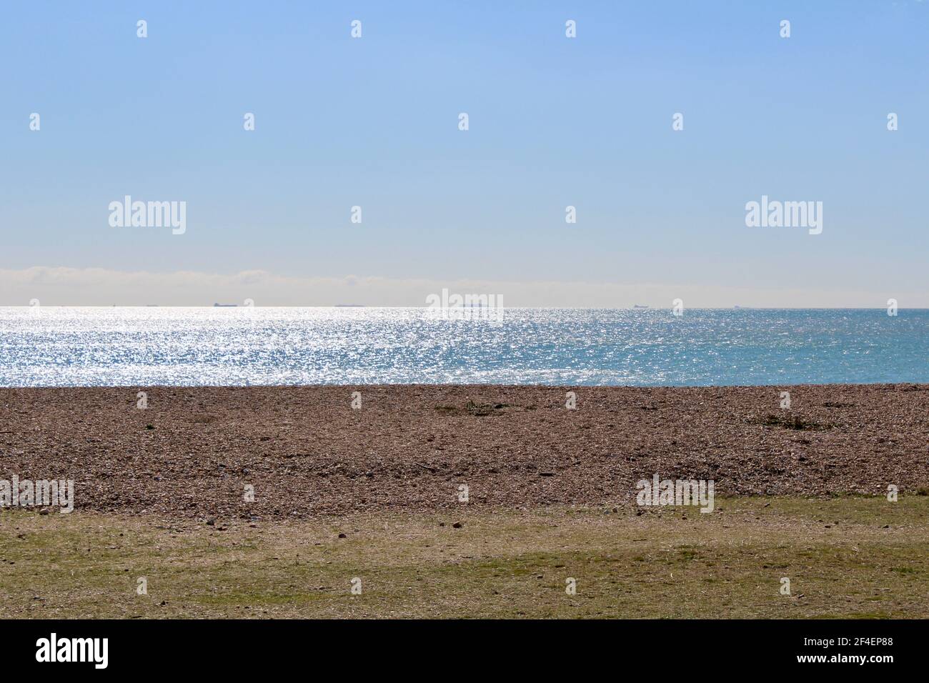 Die Strandpromenade auf Hayling Island mit nur Strand, Meer und Himmel. Blauer Himmel Kopierer Platz, um Text mit Sonnenlicht auf dem Wasser reflektiert hinzuzufügen. Stockfoto