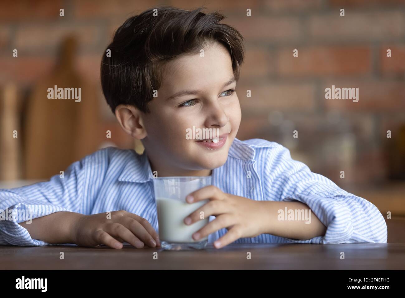 Glücklicher kleiner Junge trinken Plan Milch aus Glas Stockfoto