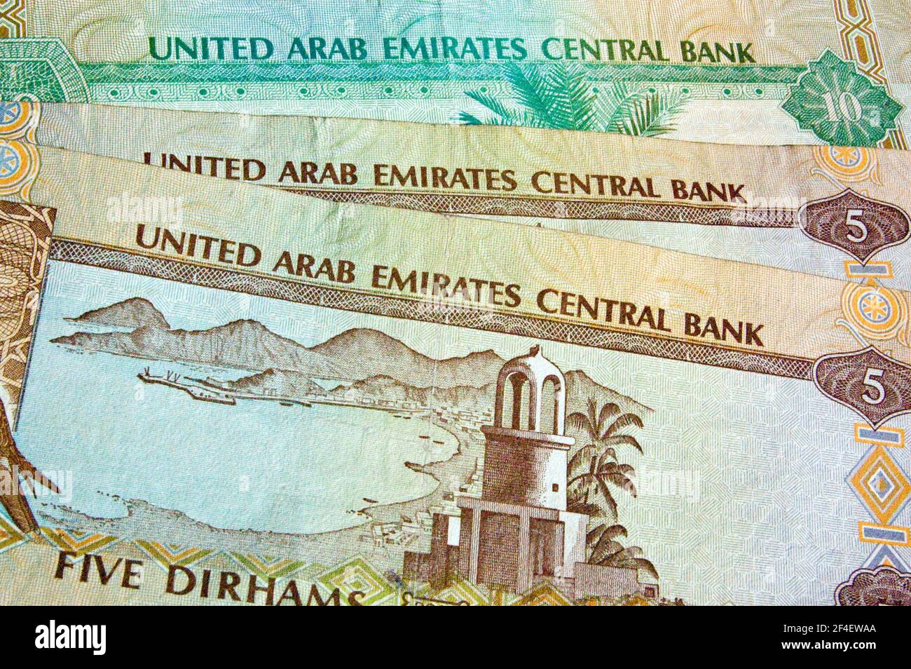 Ein Hintergrund bestehend aus Banknoten aus den Vereinigten Arabischen Emiraten, englische Seite nach oben. Die VAE bestehen aus sieben Staaten: Abu Dhabi, Dubai, Sharjah, ajma Stockfoto