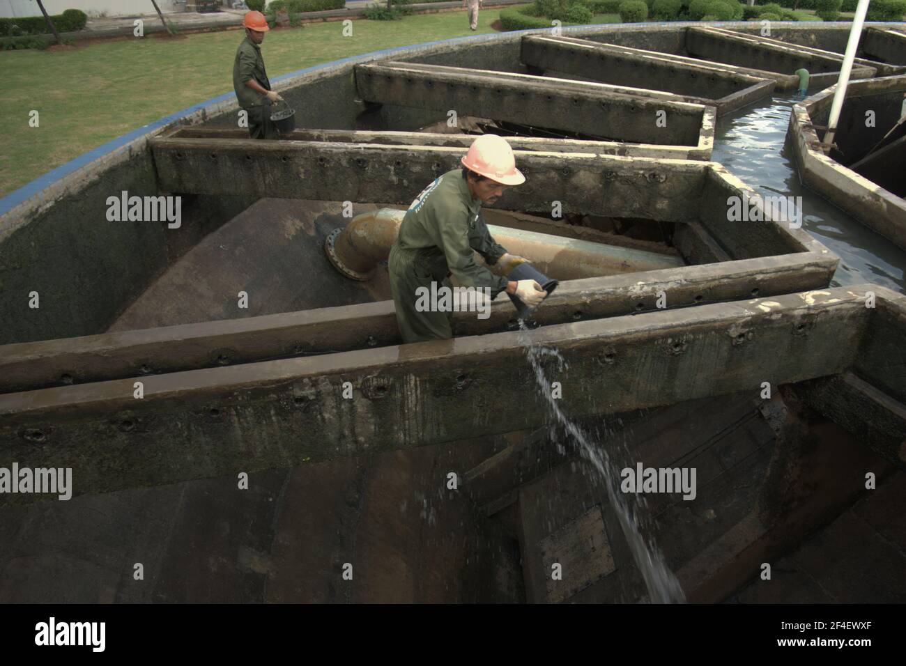 Jakarta, Indonesien. 18. Juni 2021 Arbeiter, die Wartungsarbeiten an der Quellwasseraufbereitungsanlage durchführen, einem Teil des Wasseraufbereitungskomplexes, der von einem der Wasserversorger der Jakarta, Palyja, betrieben wird, dem Eigentümer der Wasserkonzession für den westlichen Teil der indonesischen Hauptstadt. Stockfoto