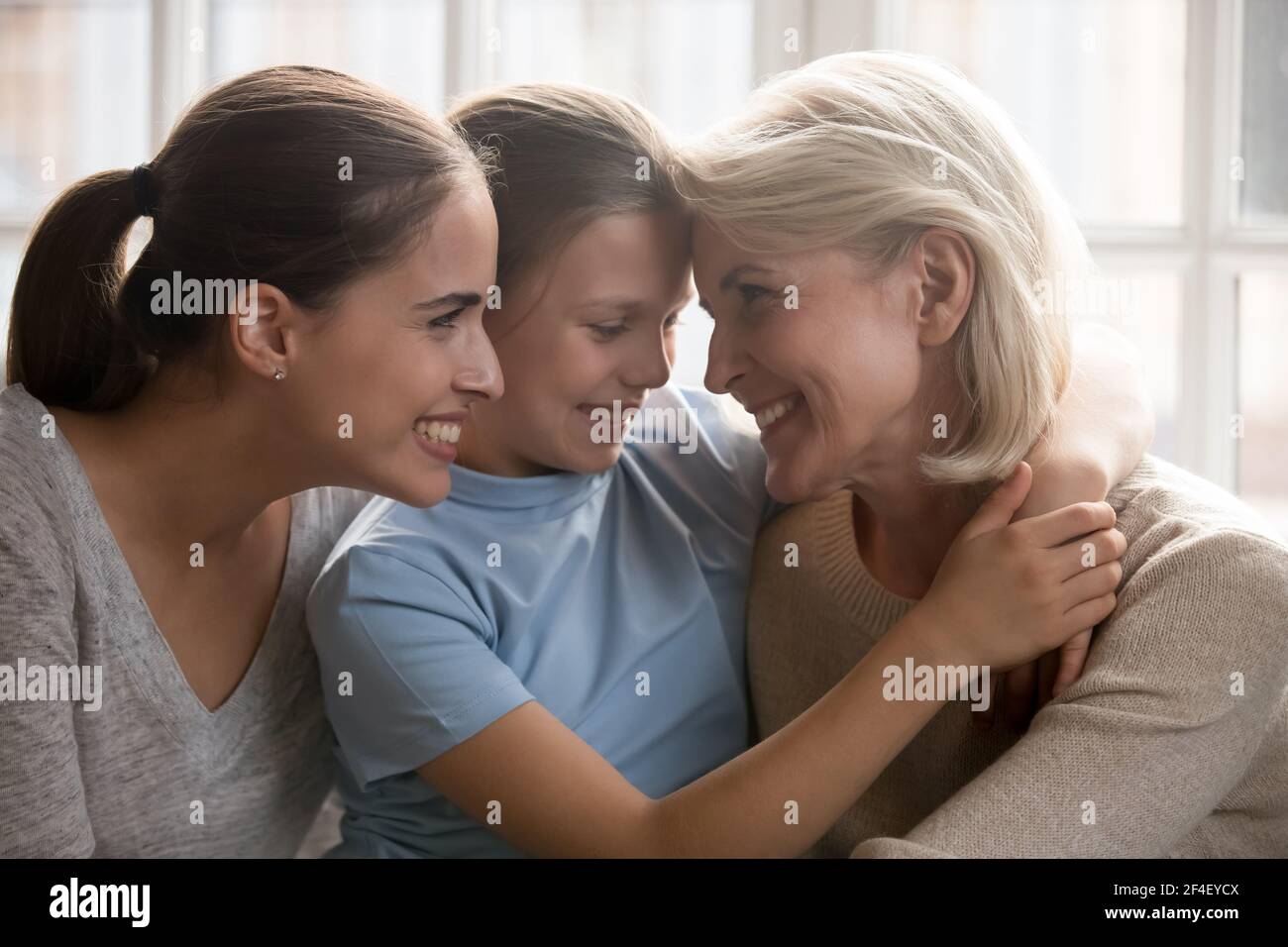 Glückliche drei Generationen von Frauen kuscheln zu Hause Stockfoto