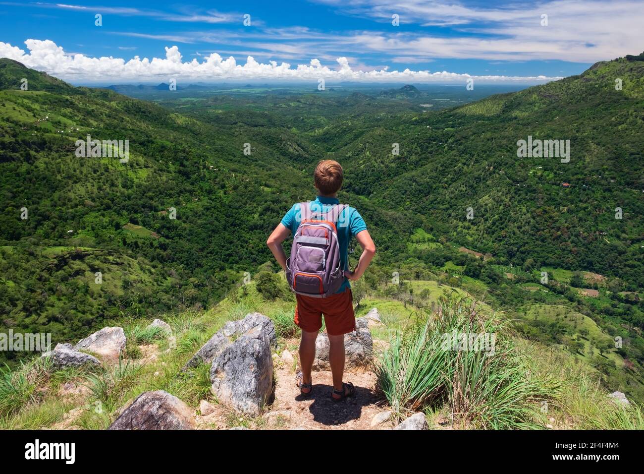 Kaukasischer männlicher Tourist, der auf dem Berg mit einer atemberaubenden Aussicht steht. Stockfoto