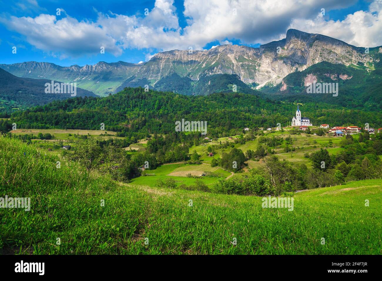 Malerisches Reise- und Wanderziel mit hohen felsigen Bergen und sommergrünen Feldern, Bergdorf Dreznica, Kobarid, Soca-Tal, Slowenien Stockfoto