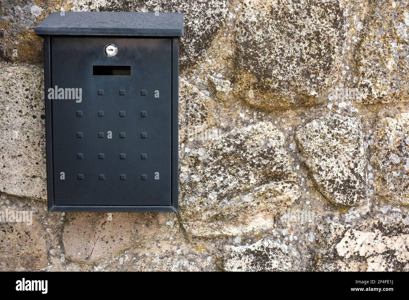 Schwarze Metall-Briefkasten an Hütte Wand Haus angeschlossen. Konzept der ländlichen Kommunikation Stockfoto