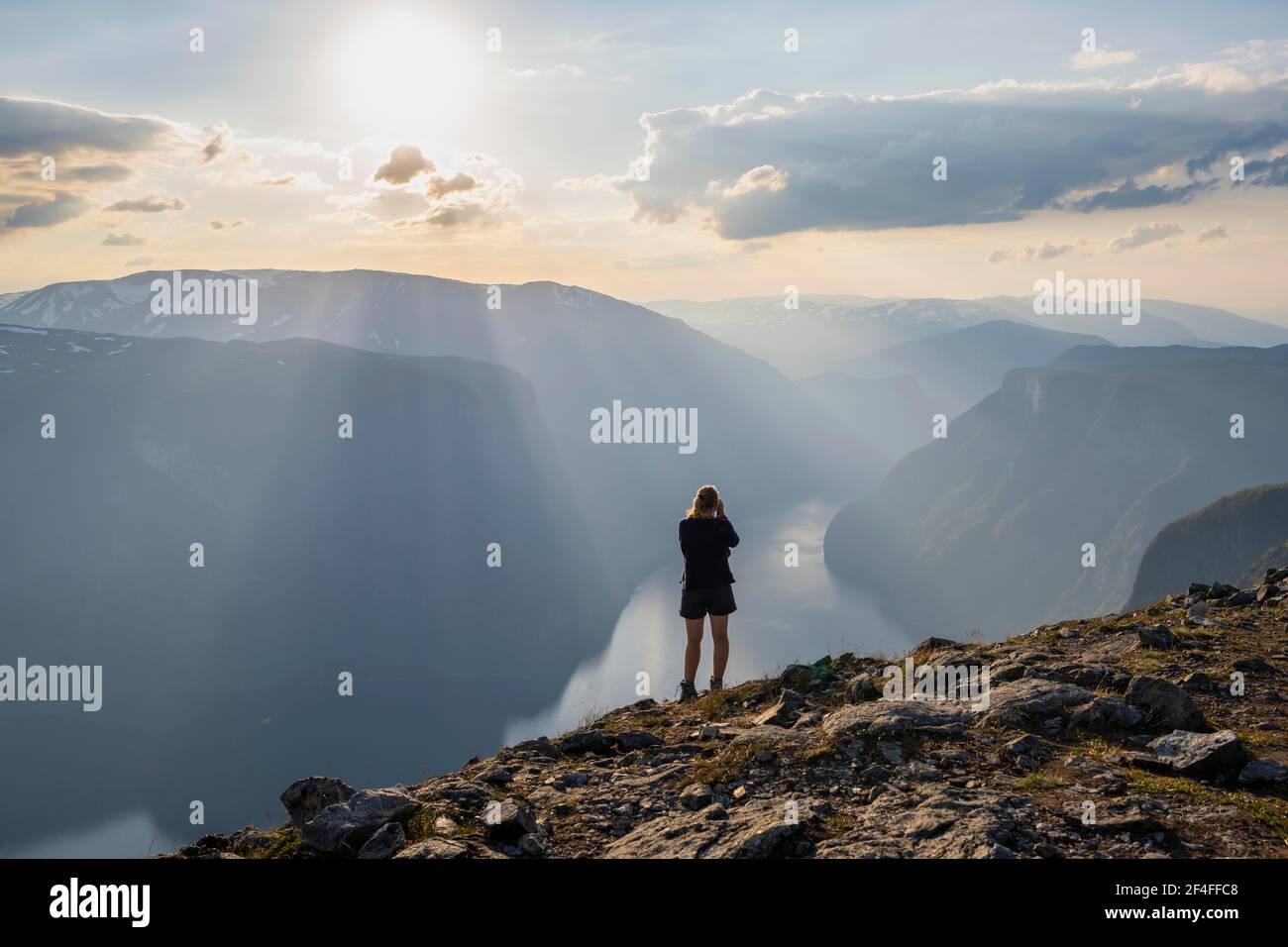 Wanderer fotografieren Fjordlandschaft, Gipfel des Berges Prest, Fjord Aurlandsfjord, Aurland, Norwegen Stockfoto